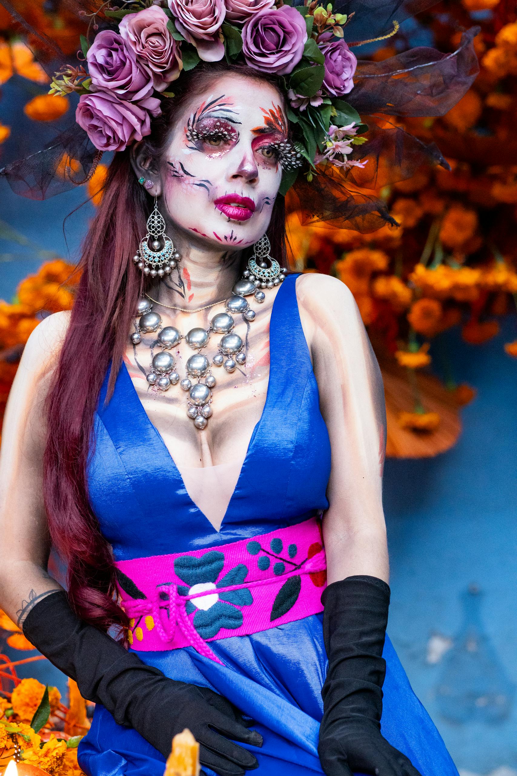 Colorful Catrina costume featuring floral headdress and traditional makeup during Day of the Dead.